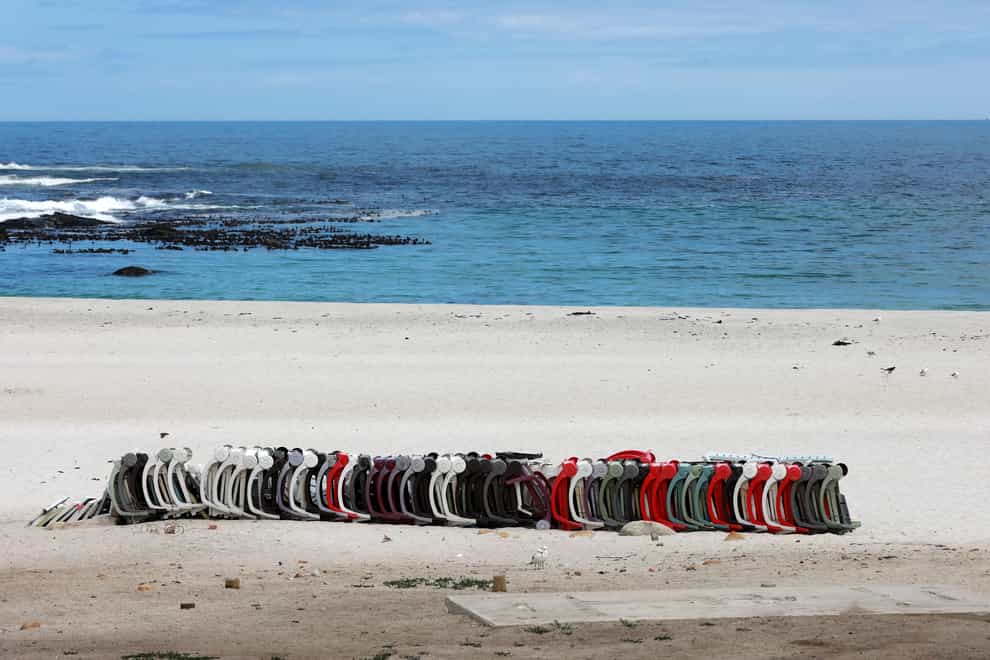 Stacked beach chairs lay on the closed beach in Camps Bay, Cape Town (Nardus Engelbrecht/AP)