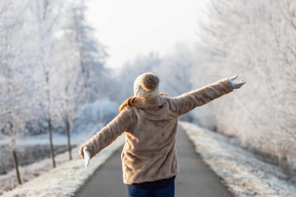 Happy woman enjoying fresh air during walk in winter nature