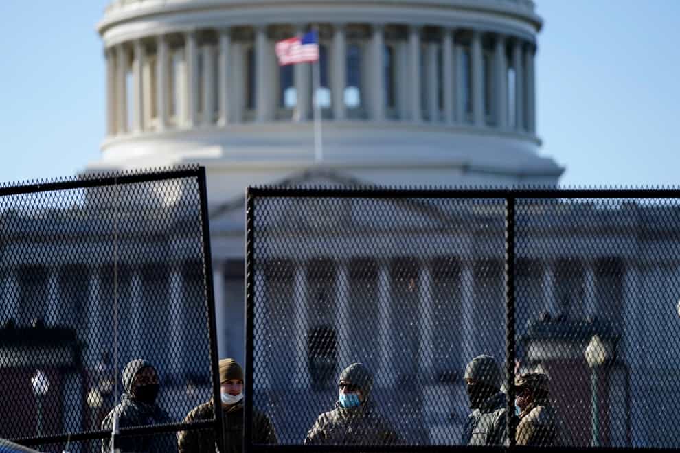 With the US Capitol in the background, authorities stand behind newly placed fencing (Evan Vucci/AP)