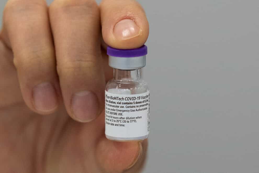 An employee of the Municipal Health Service GGD shows the Pfizer-BioNTech Covid-19 vaccine prior to administering it to a health care worker in the Netherlands (Peter Dejong/AP)
