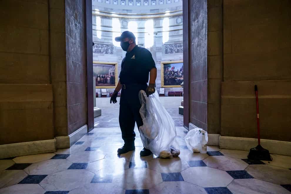 A workman cleans up debris outside the office of Speaker of the House Nancy Pelosi (J. Scott Applewhite/AP)