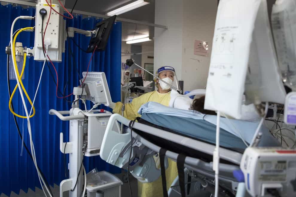 A nurse works on a patient in the ICU