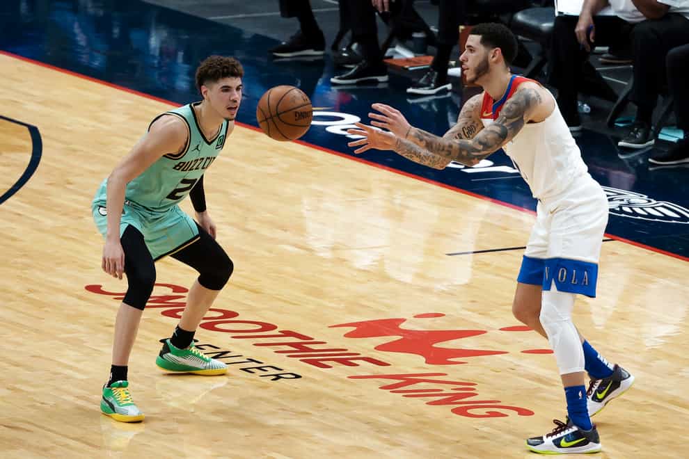 New Orleans Pelicans guard Lonzo Ball passes the ball as his brother, Charlotte Hornets guard LaMelo Ball defends during the second quarter of their NBA match in New Orleans