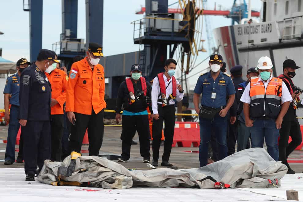 Rescuers inspect debris found in waters near where a Sriwijaya Air passenger jet crashed on Saturday