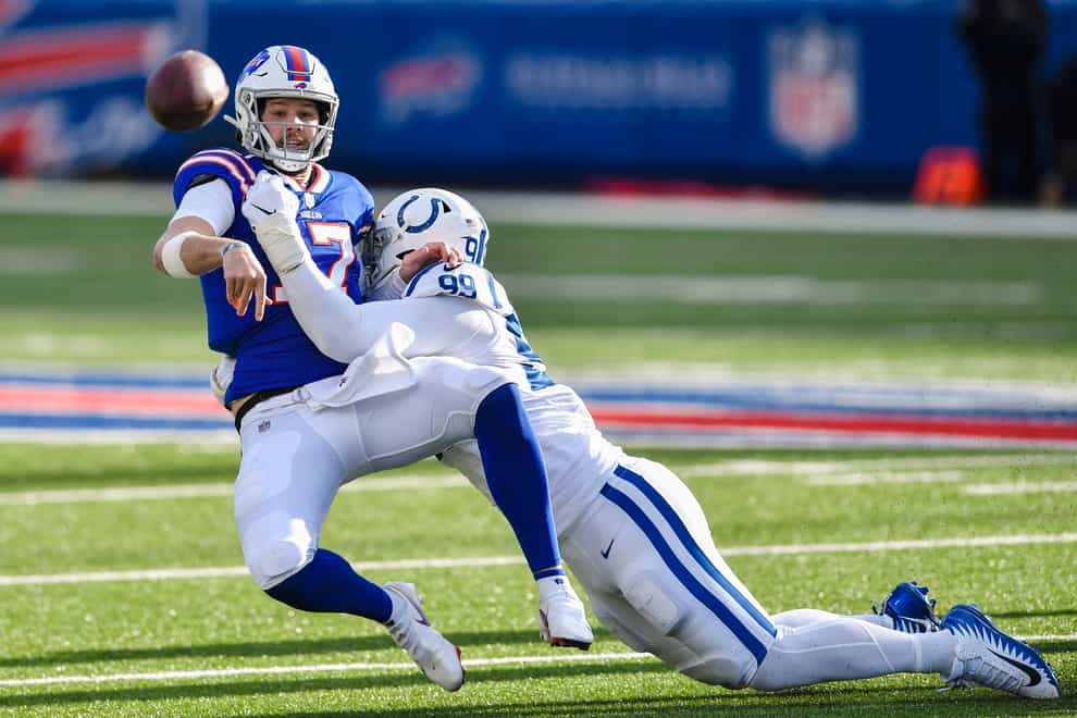Buffalo Bills quarterback Josh Allen (17) throws a pass as he is hit by a defender
