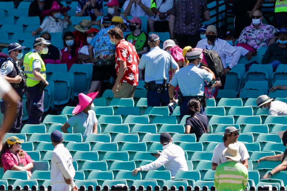 Police escort spectators from the stands during play on day four of the third Test between India and Australia at the SCG