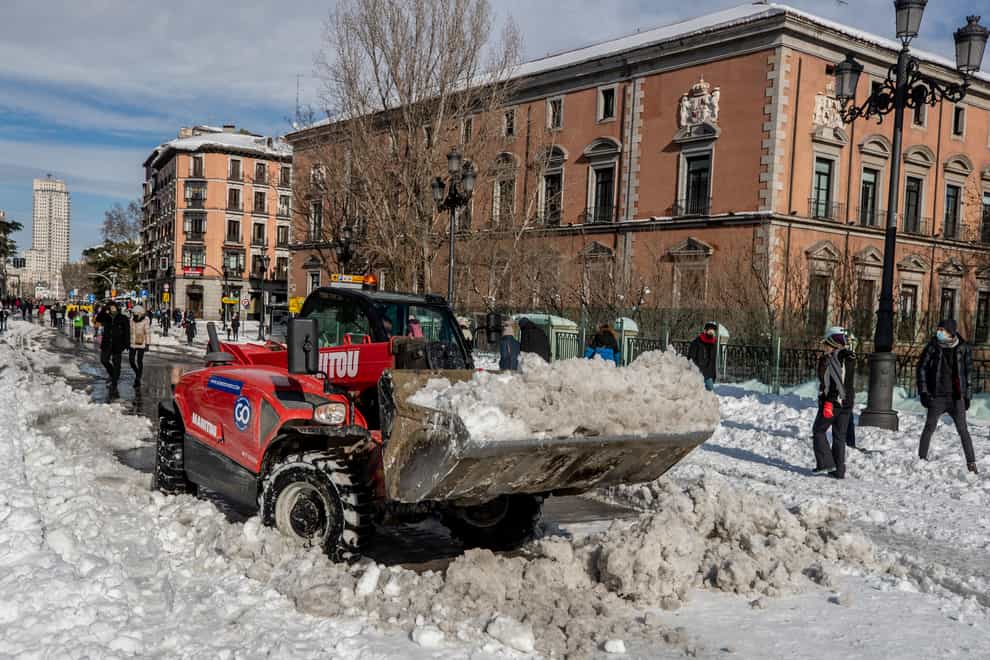 A plough clears snow in central Madrid (Manu Fernandez/AP)