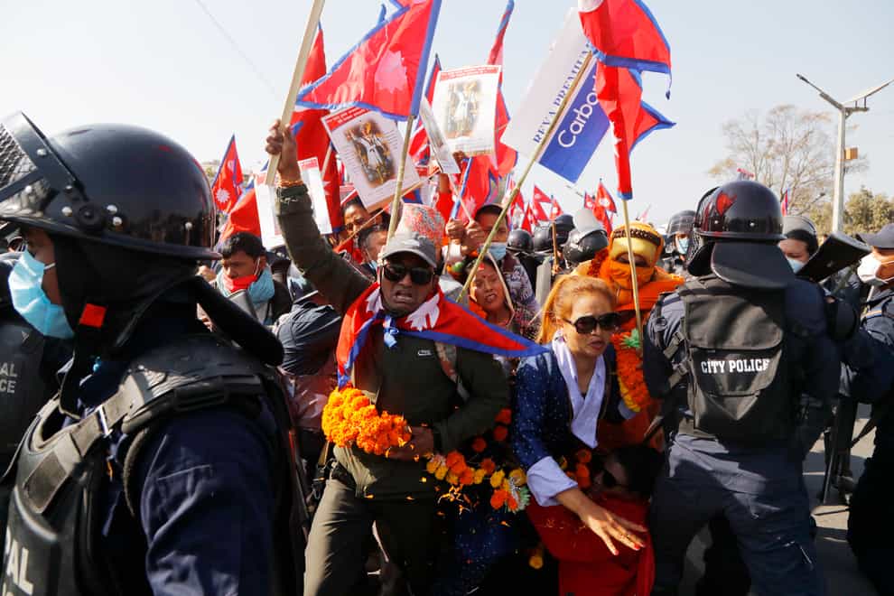 Pro-king supporters are stopped by riot police as they march demanding reinstating the monarchy that was abolished more than a decade ago in Kathmandu, Nepal (Niranjan Shrestha/AP)