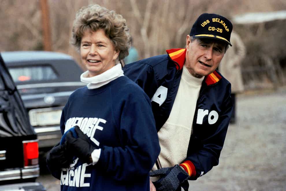 President George H. W. Bush pictured in 1990 hiding behind his sister, Nancy Ellis, as he prepares for a jog along the C&O canal in the Georgetown section of Washington (Marcy Nighswander/AP)