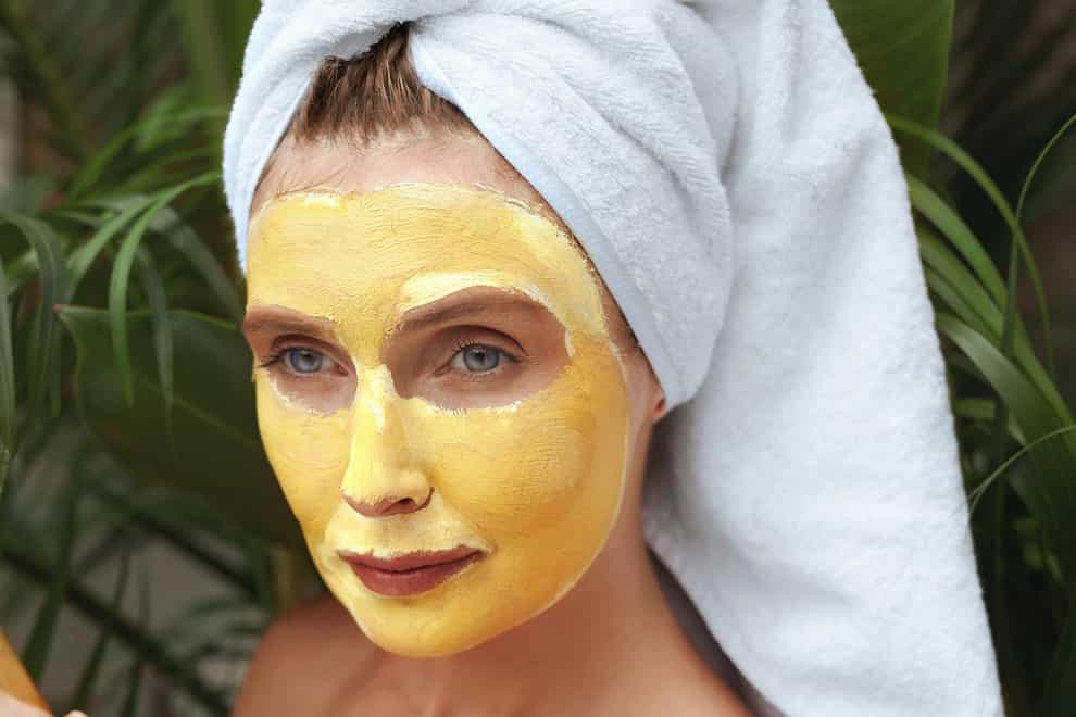 woman applying turmeric face mask