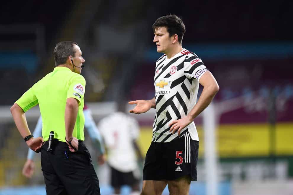 Harry Maguire (right) talks to referee Kevin Friend