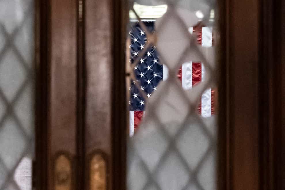Broken glass from last week’s confrontation with a pro-Trump mob is seen in the door to the House chamber at the Capitol (J. Scott Applewhite/AP)