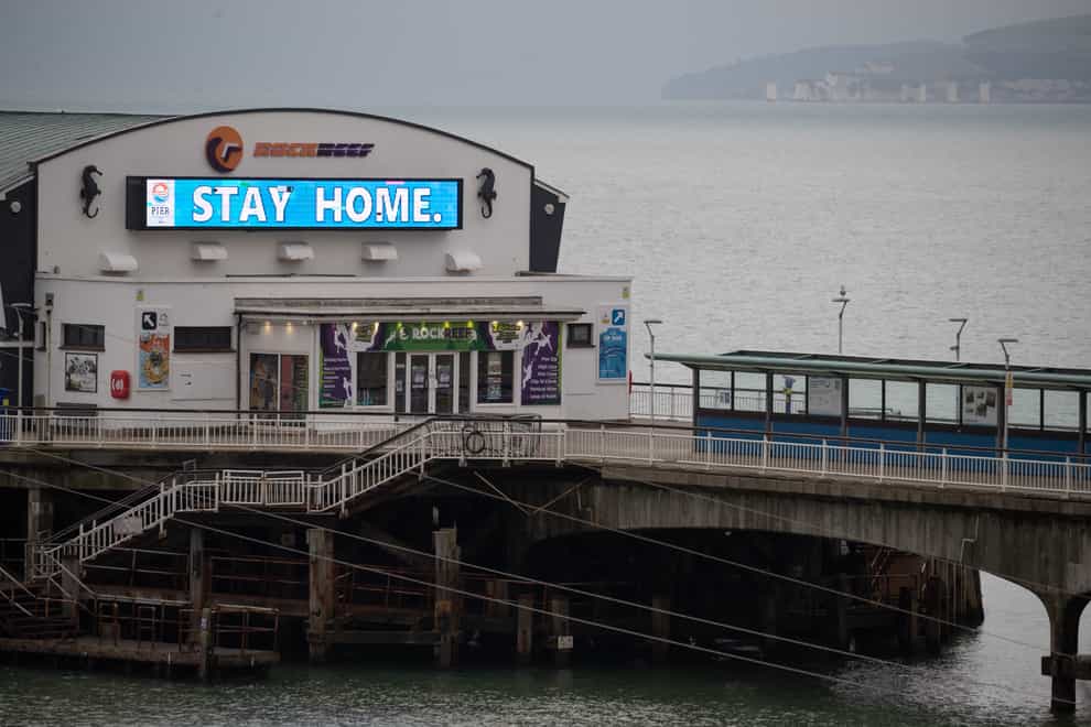 A ‘Stay Home’ sign is displayed on Bournemouth pier in Dorset