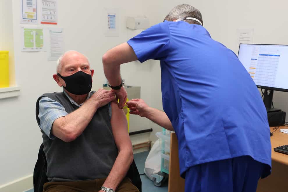 Pharmacist Andrew Hodgson administers a dose of the coronavirus vaccine to Robert Salt, 82, at Andrews Pharmacy in Macclesfield, Cheshire