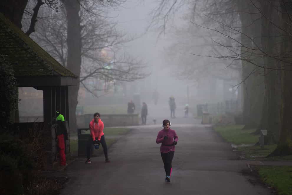 A runner in a foggy park