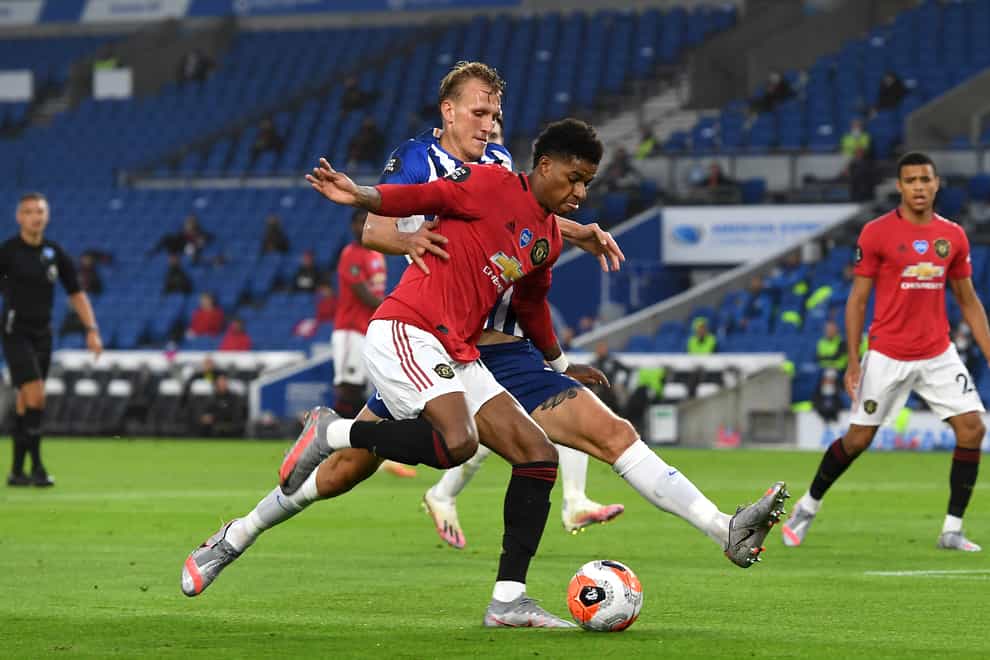 Manchester United’s Marcus Rashford goes down under the challenge from Brighton’s Dan Burn in penalty area