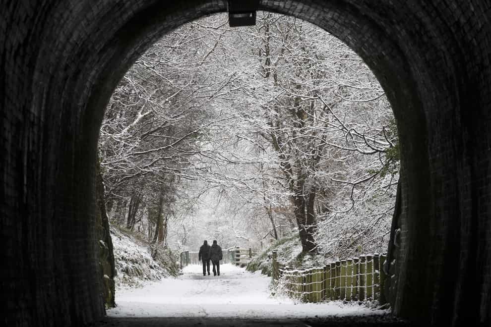 A couple walk through the snow