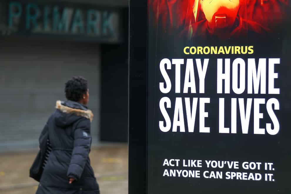 A person walks past a ‘Stay Home Save Lives’ government sign on Commercial road in Portsmouth during England’s third national lockdown