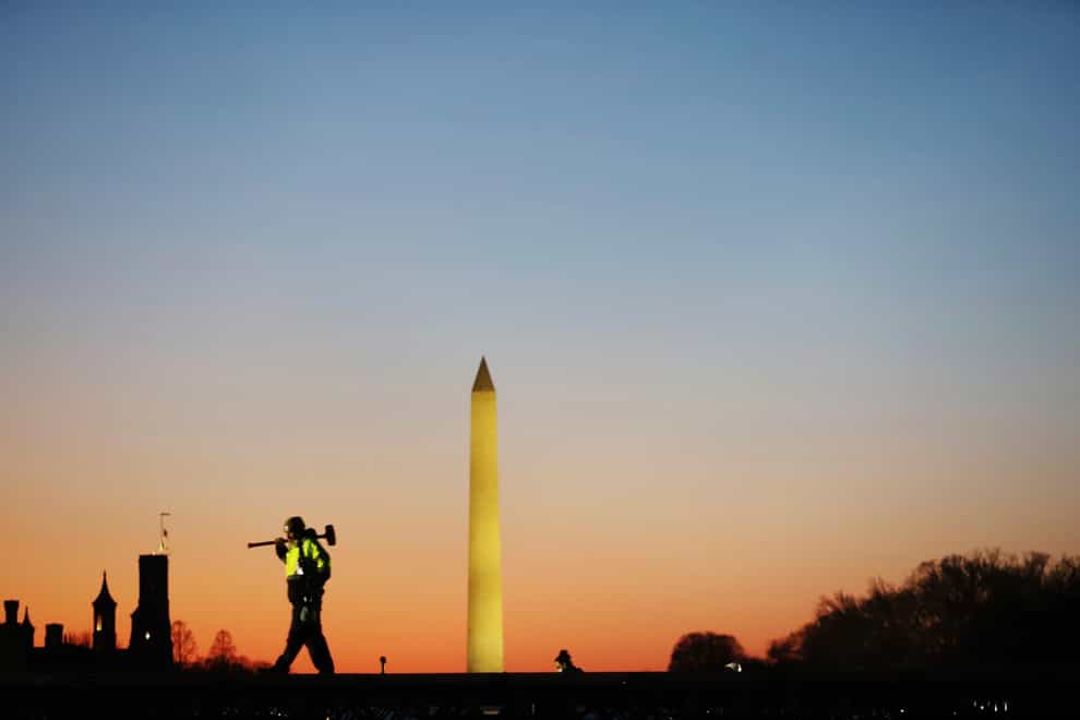 A construction worker carries a hammer at the National Mall in Washington DC (Biden Inauguration/AP)