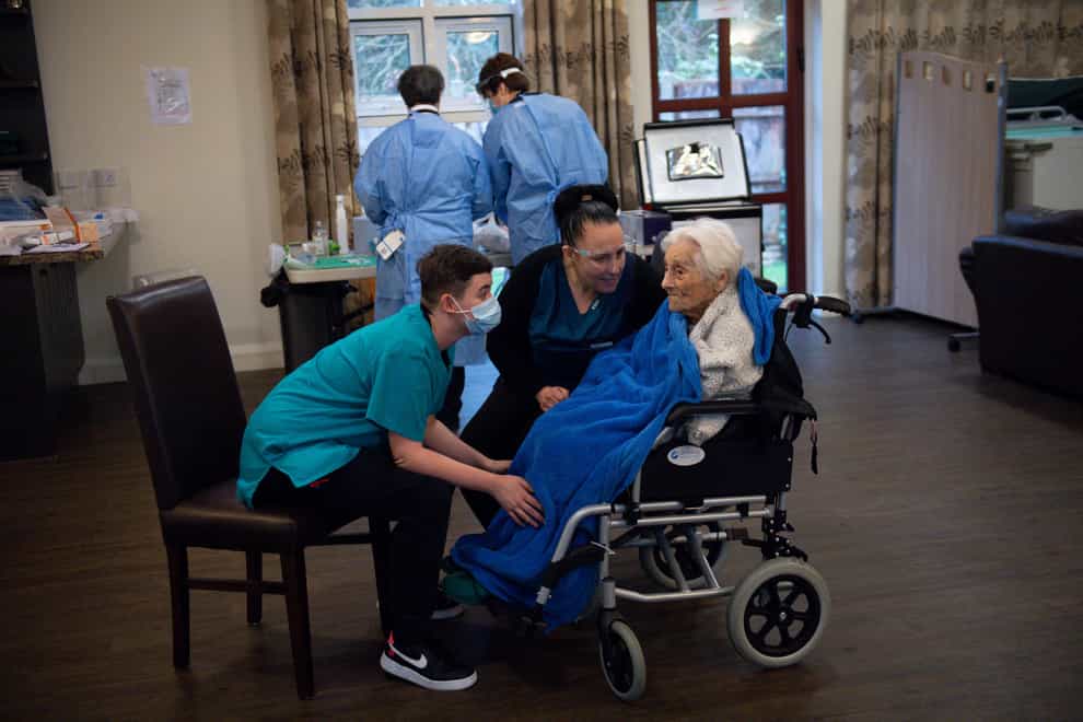 Care home workers comfort a resident