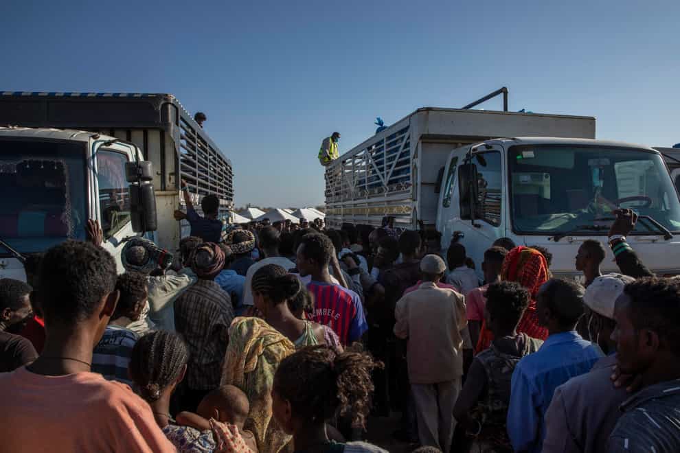 Tigray refugees who fled the conflict in Ethiopia’s Tigray region, wait to receive aid at Umm Rakouba refugee camp in Qadarif, eastern Sudan (Nariman El-Mofty/AP)