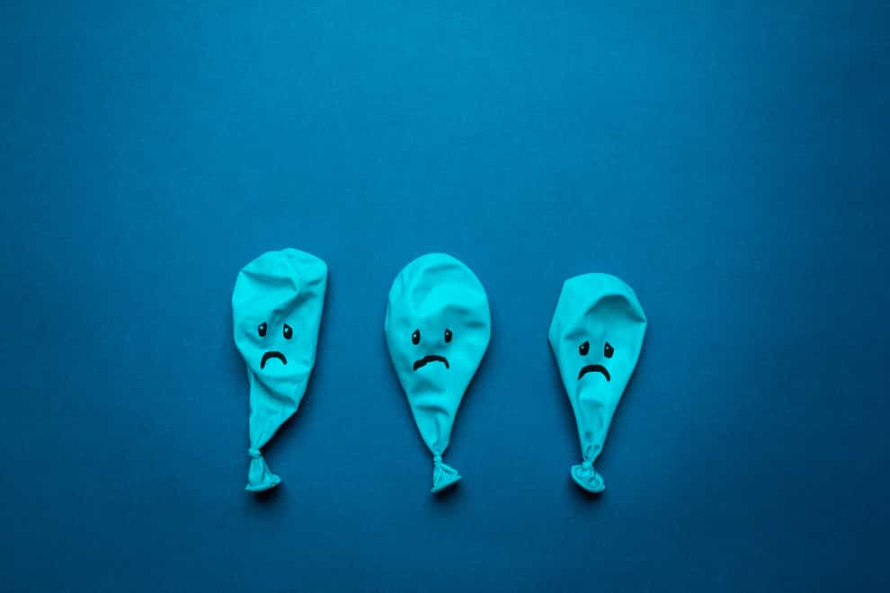 three popped blue balloons with sad faces