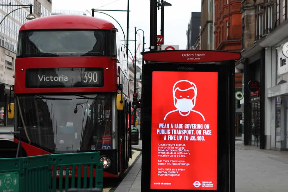 A bus advert advising the wearing of face coverings in Oxford Street, London