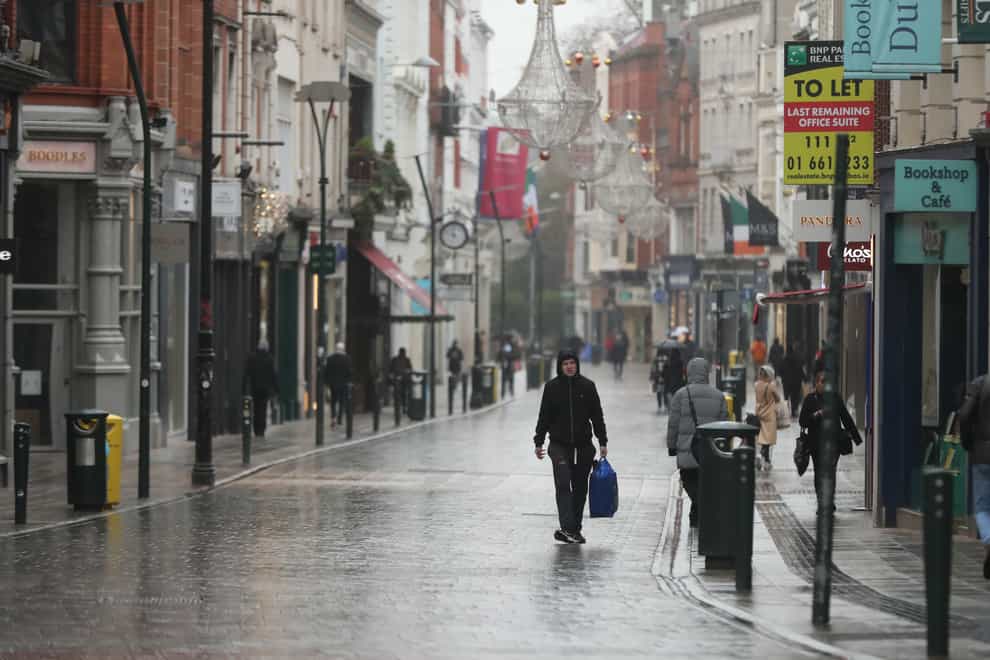 People walk along a near empty Grafton Street in Dublin city centre as Ireland remains in lockdown to help prevent the spread of coronavirus