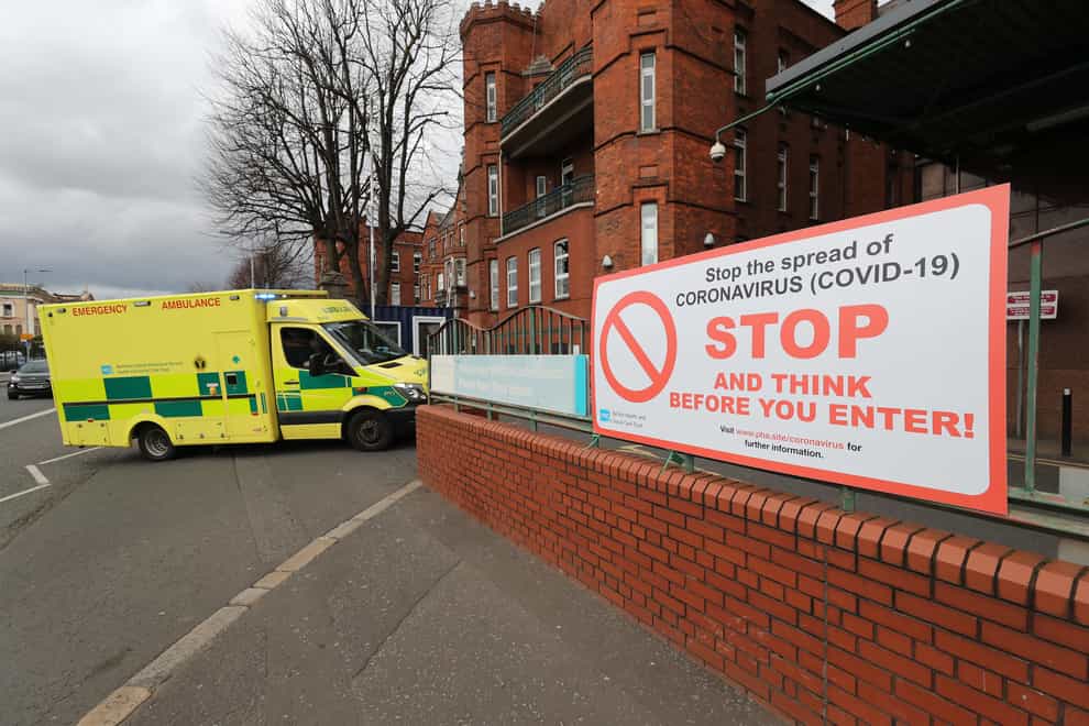 An ambulance and Covid-19 warning sign outside a hospital