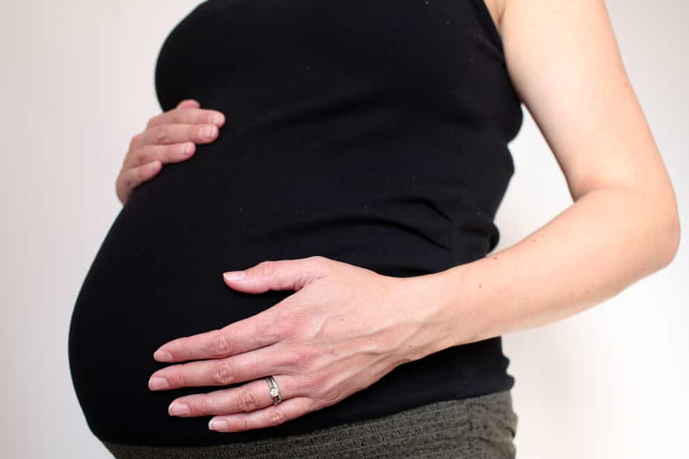 A woman cradles her pregnant stomach