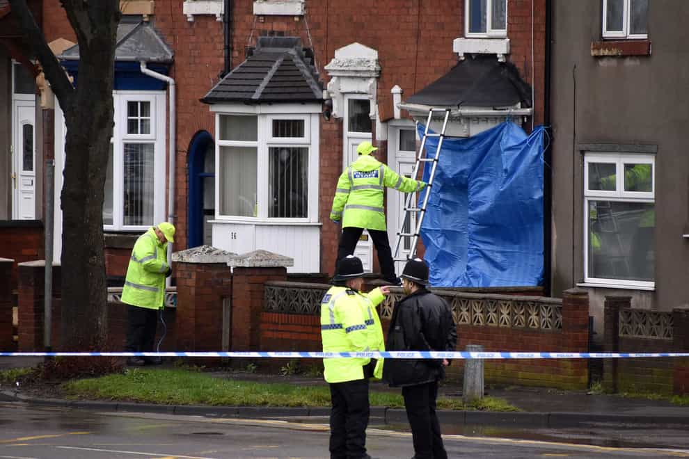 Police staff cover broken windows of a property on Pensnett Road, Brierley Hill, West Midlands,