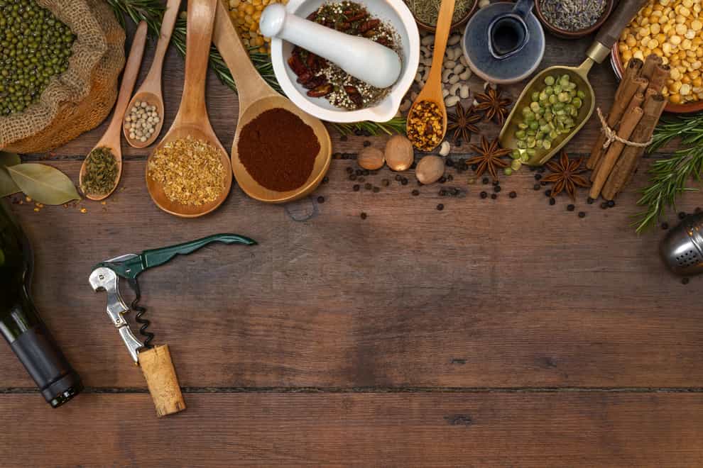 An array of herbs and spices alongside a bottle opener