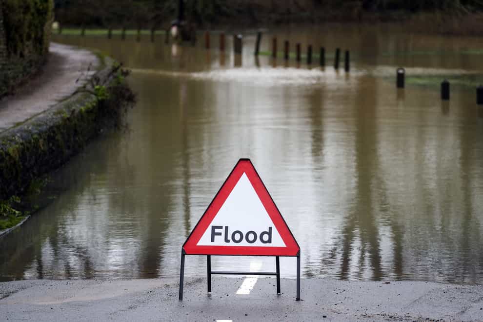 A flood warning sign surrounded by water