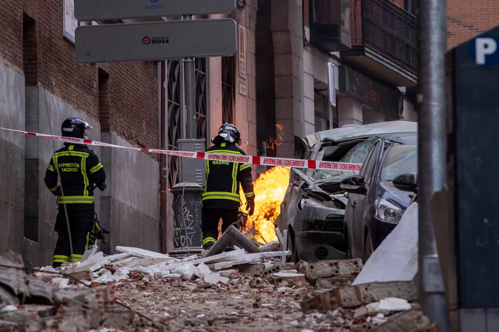 Firefighters inspect the debris caused by an explosion in Madrid, Spain