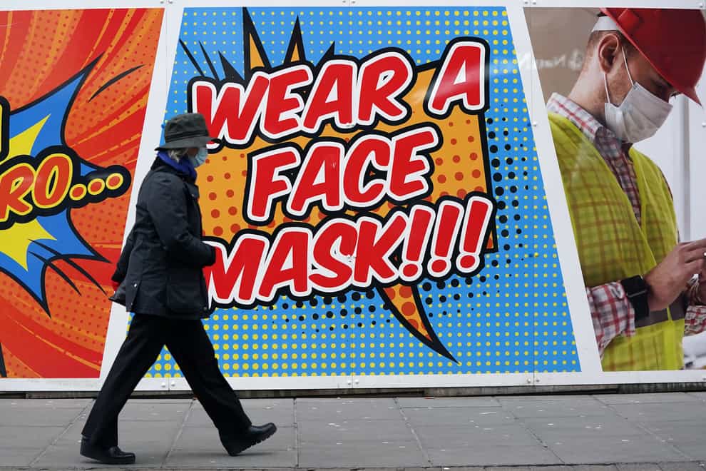 A person walks past a sign telling people to wear a face mask in Nottingham