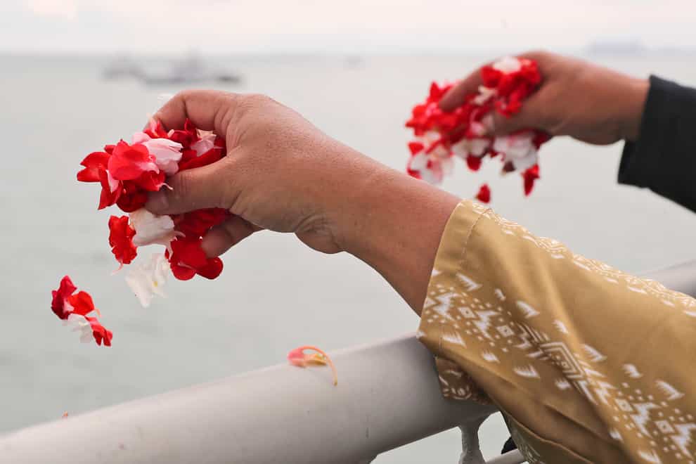 Relatives sprinkle flowers into the Java Sea where Sriwijaya Air flight SJ-182 crashed on January 9