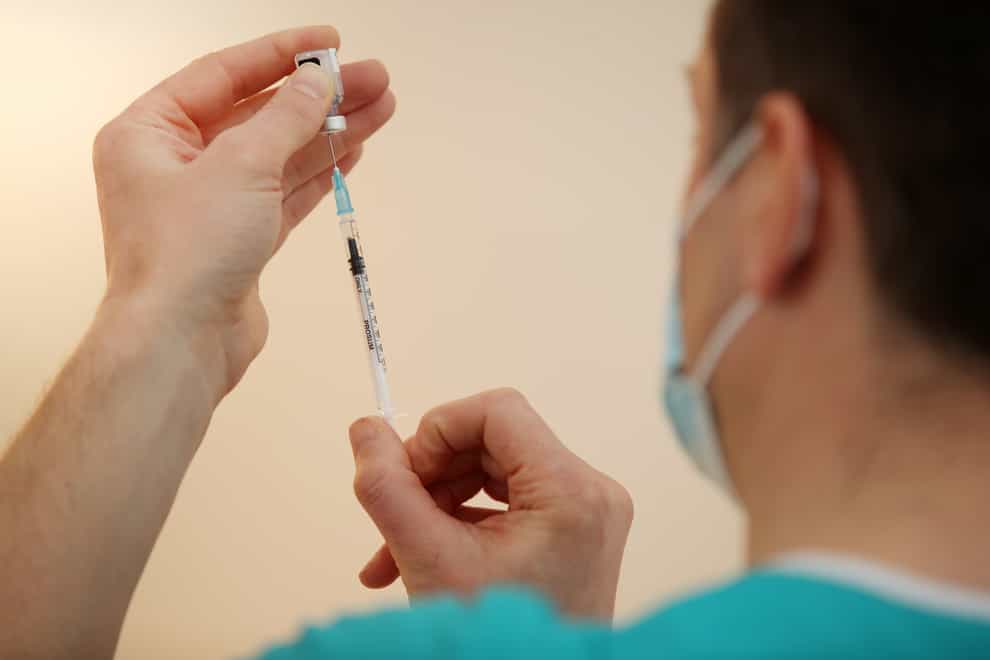A doctor draws the BioNTech/Pfizer Covid-19 vaccine before injecting into the arm of a patient