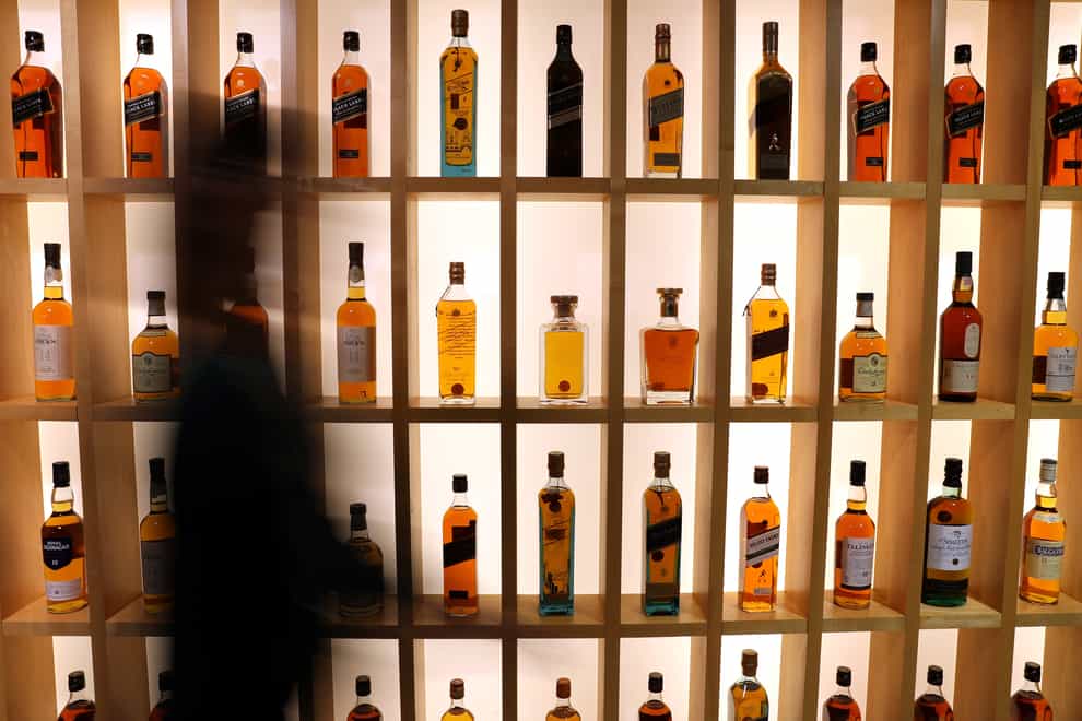 A person walks past Diageo-owned whiskies on the whisky wall at its headquarters in Edinburgh