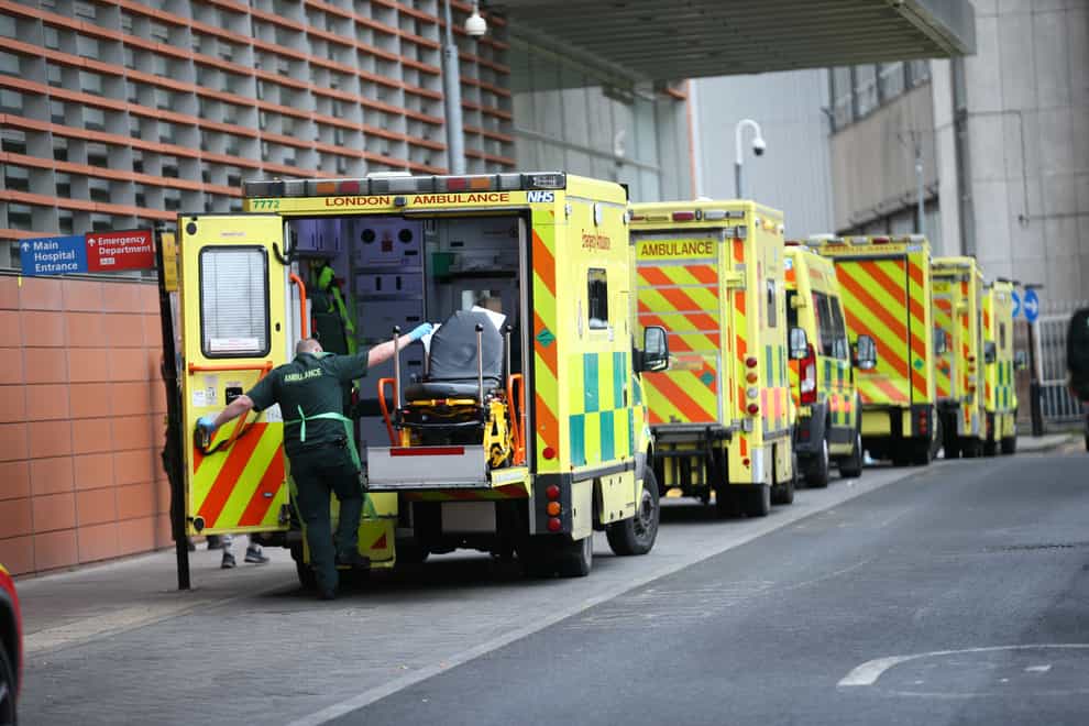 A paramedic and ambulances outside a hospital