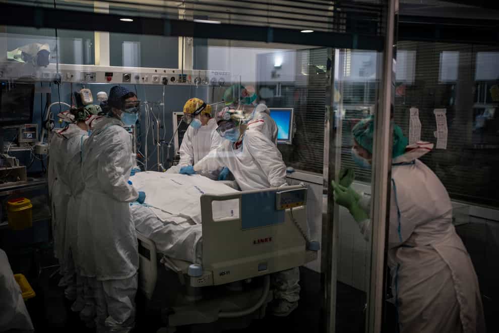 Medics treat a patient in a hospital ICU