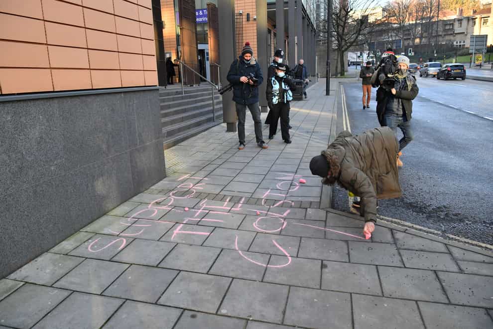 A woman writes Support The Colston 4 in chalk outside Bristol Magistrates’ Court (Ben Birchall/PA)