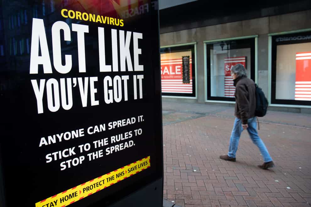 A person passes an ‘Act like you’ve got it’ government coronavirus sign