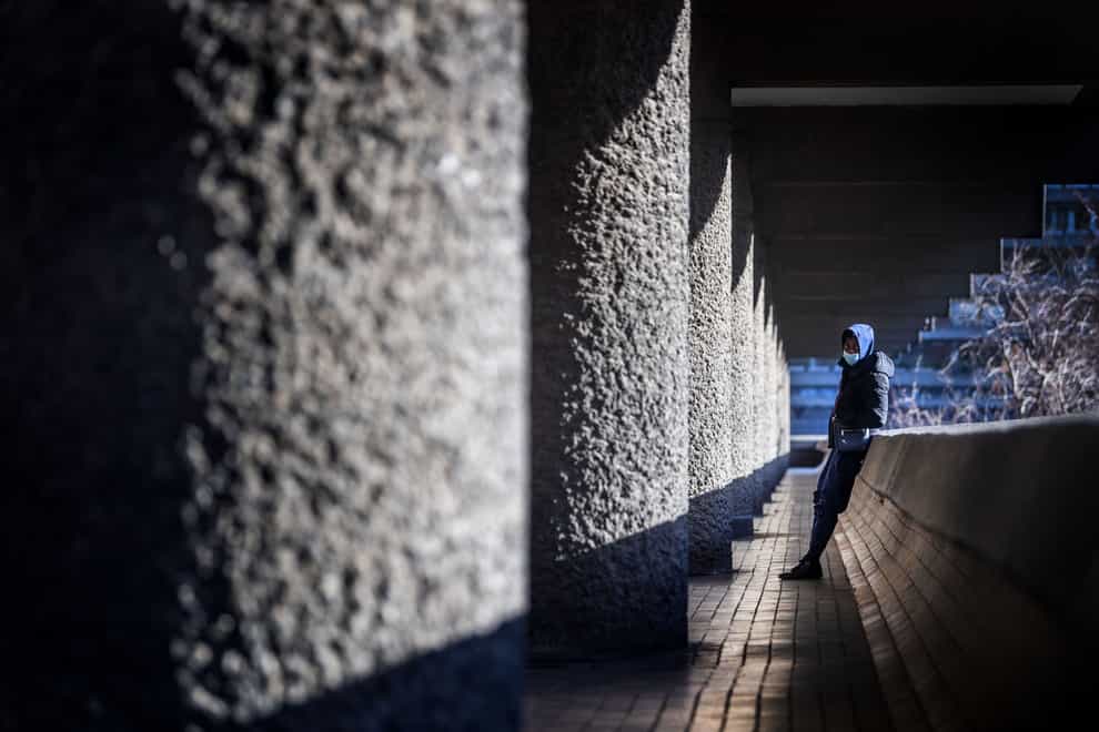 A man wearing a facemask in the Barbican Estate in London (Victoria Jones/PA)