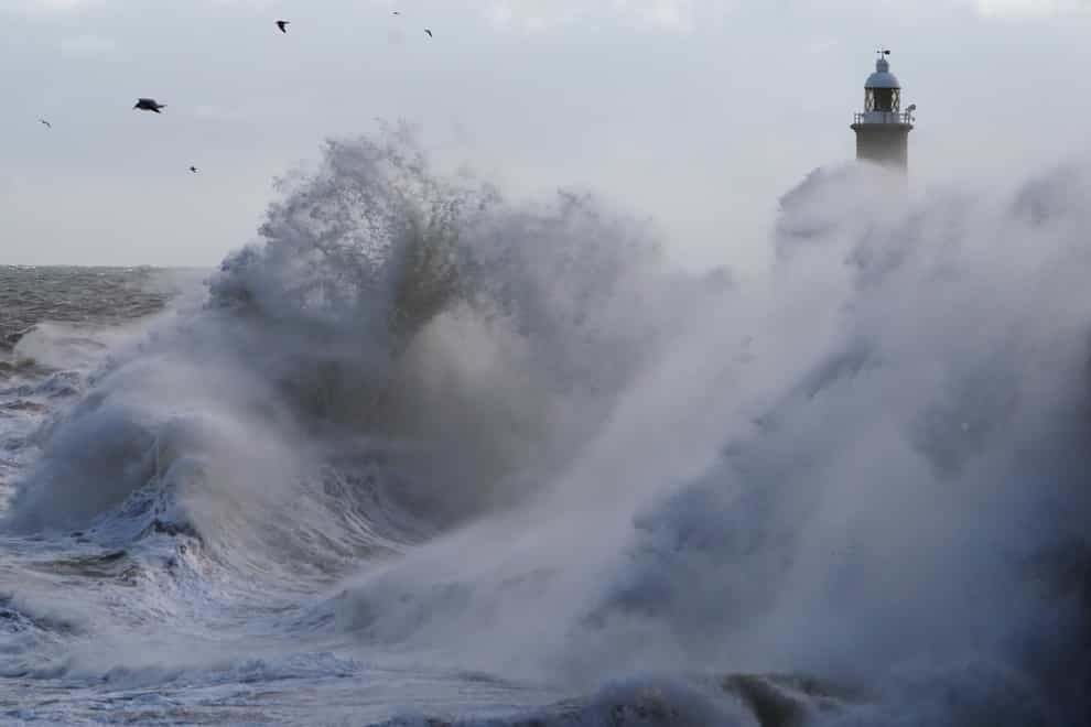 Waves crash against the pier wall at Tynemouth on the North East coast of England