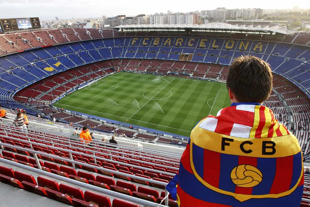 A Barcelona fan looks out over a near-empty Nou Camp