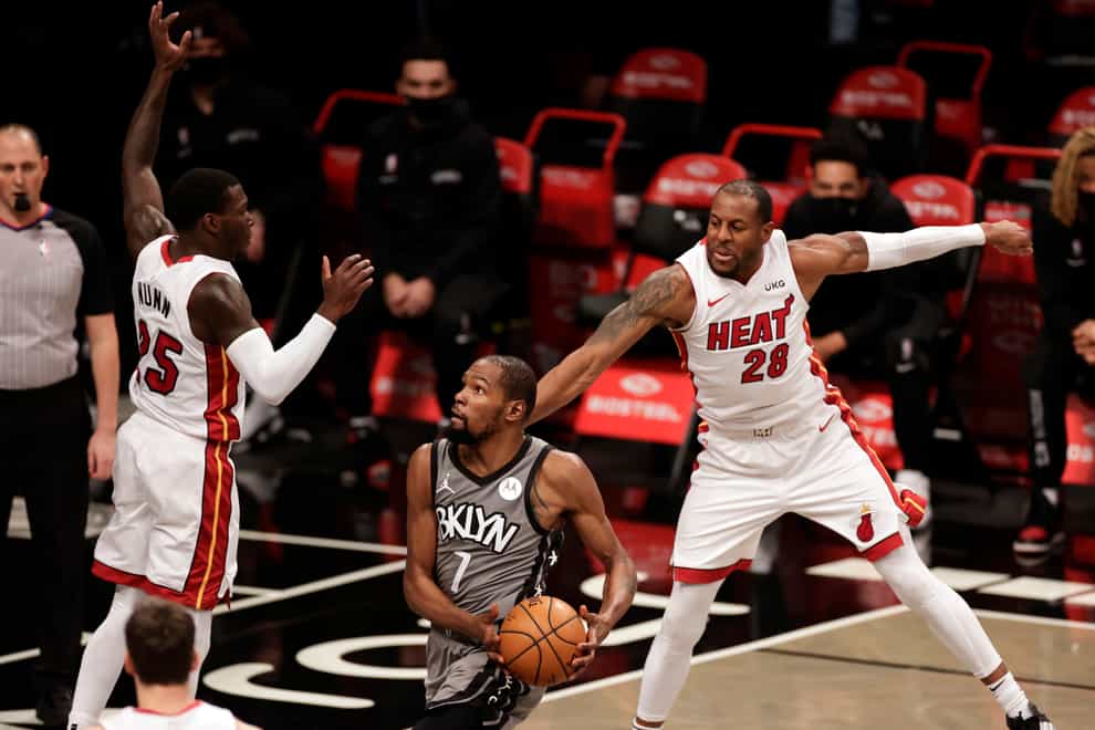 Brooklyn Nets forward Kevin Durant drives to the basket between Miami Heat forward Andre Iguodala and guard Kendrick Nunn
