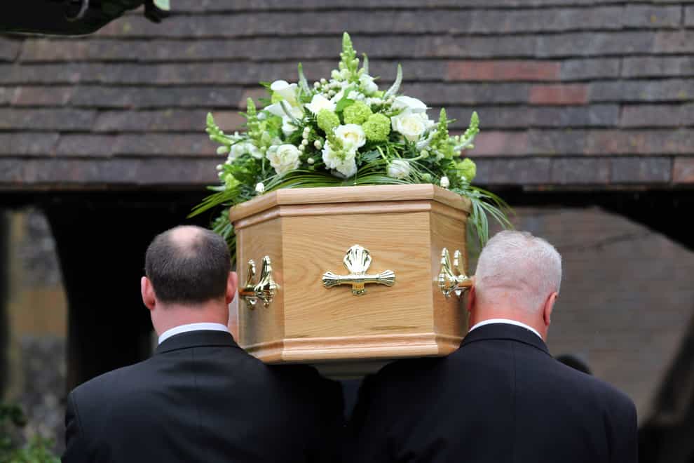 Pallbearers carry a coffin