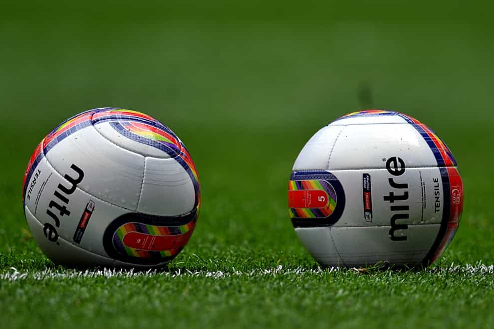 Two footballs on a pitch