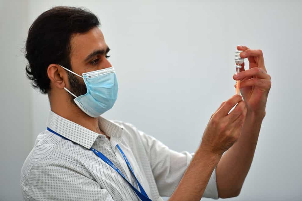 A pharmacist prepares a coronavirus vaccine
