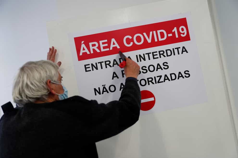 A worker puts up a sign on the door of a new Covid-19 ward being set up at the Military Hospital in Lisbon
